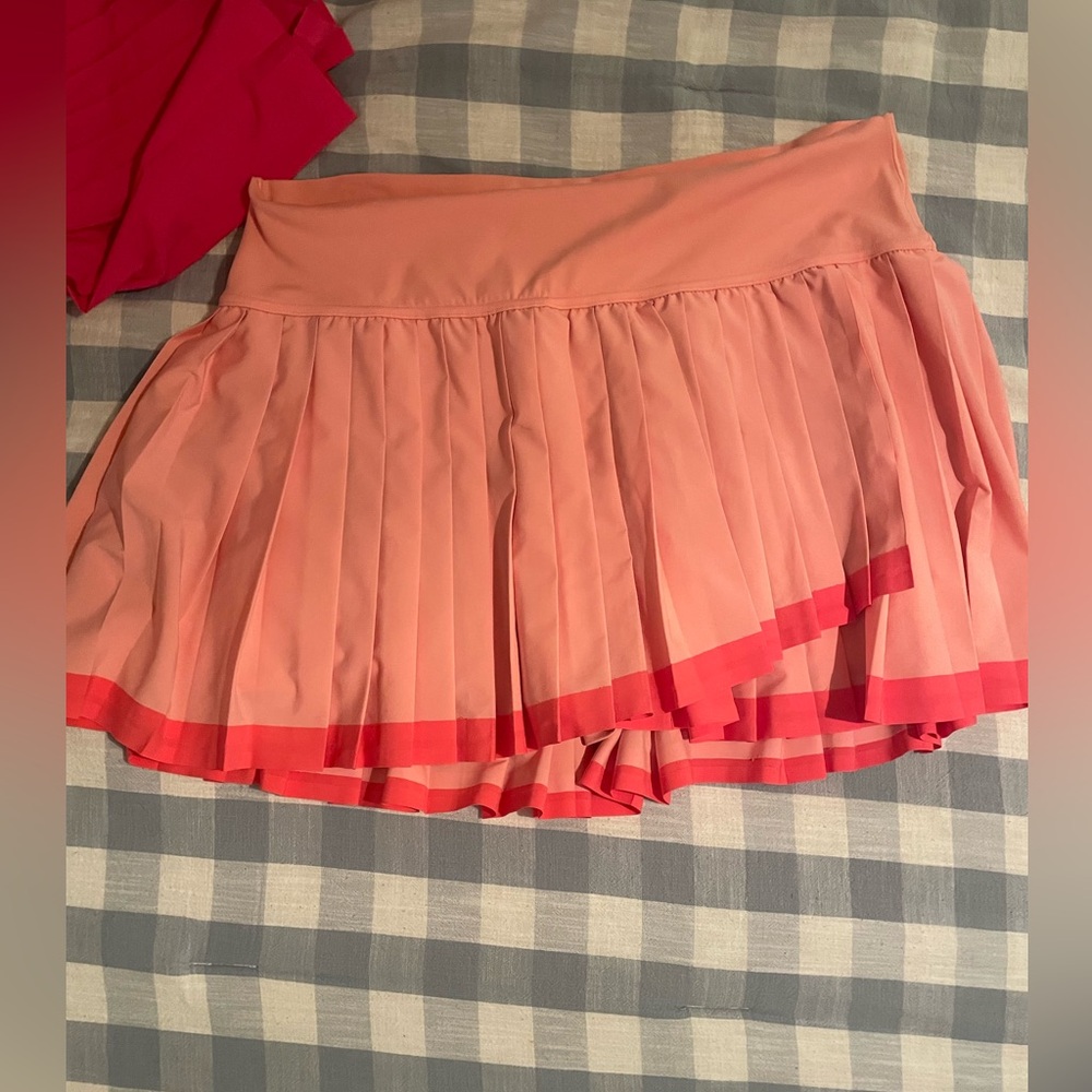 Pink pleated athletic skort. Asymmetrical hem.